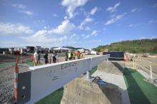 a white construction beam adorned with signatures that will be placed on the bioforge structure
